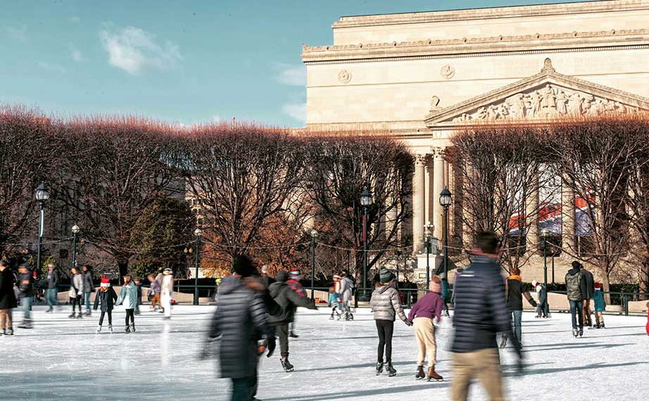 people ice skating in front of the national gallery of art