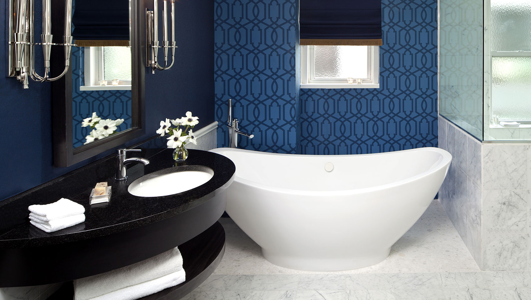 Guestroom bathtub and shower with marble tiles