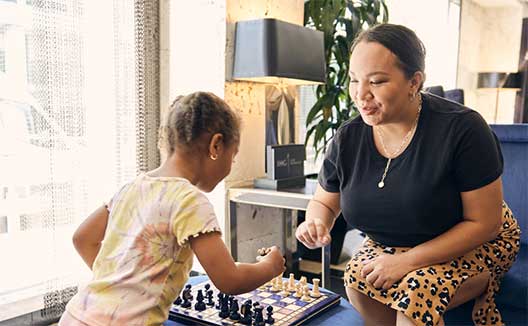 mother and child playing chess at Kimpton George hotel