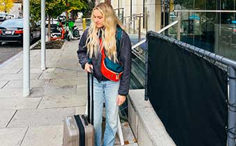 woman wit suitcase outside of Kimpton George Hotel
